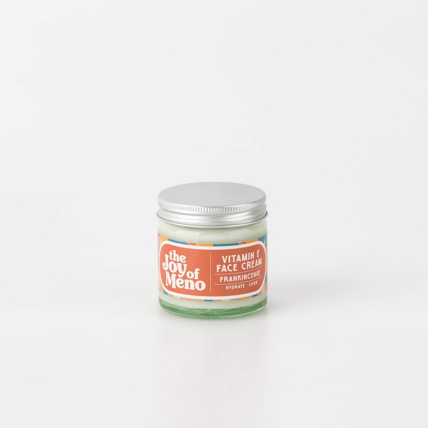 60ml clear glass jar of an off white face cream, with an orange coloured patterned label with white text.